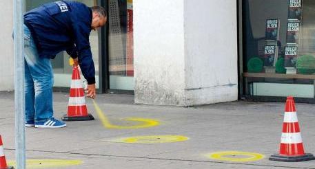Hannover: Ein Beamter markiert Patronenhülsen vor der Disco mit Sprühfarbe.