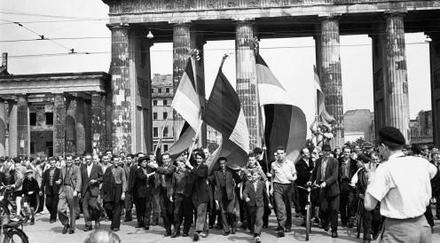Fahnentragende, ostdeutsche Demonstranten marschieren am 17.06.1953 durch das Brandenburger Tor nach West-Berlin, nachdem ein blutiger Aufruhr gegen die Sowjetunion im Ostsektor ausbrach