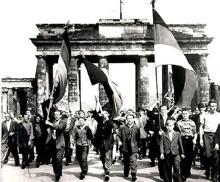 Aufstand des 17. Juni 1953 - Arbeiter mit schwarz-rot-goldenen Fahnen ziehen durch das Brandenburger Tor in den Westteil Berlins.