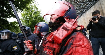 Photographer takes pictures of a German riot policeman, hit by a paint bomb, during an anti-capitalism "Blockupy" demonstration in Frankfurt
