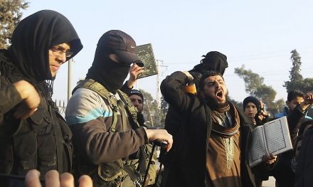Fighters from the Islamic State in Iraq and the Levant (ISIL) try to calm civilians demonstrating against the rebel infighting in Aleppo