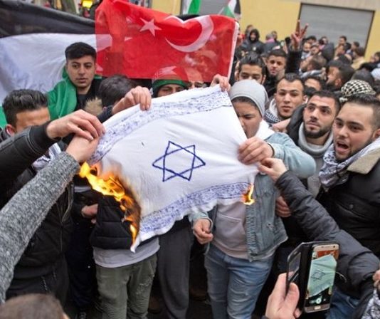 Moslems zünden in Berlin eine Israel-Flagge an.