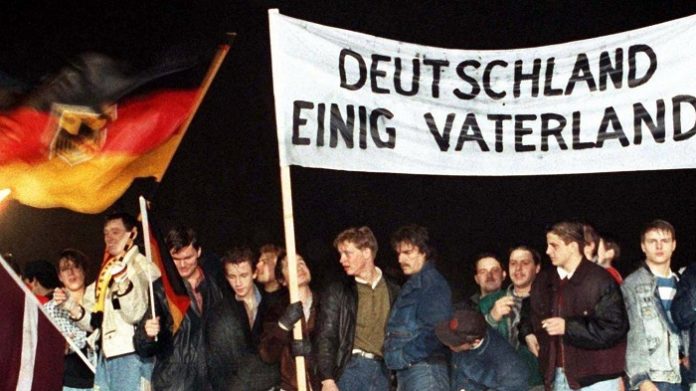 Wir brauchen endlich eine Wiedervereinigung 2.0 – eine wahre Widervereinigung (Foto: Junge Deutsche Ende Dezember 1989 auf der Mauer am Brandenburger Tor).