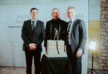 Erik Lehnert, Götz Kubitschek und Björn Höcke mit dem von einem Steinmetz angefertigten Werkstück zum Jubiläum, eines an den Händen geketteten Mannes, der den Riß  überschreitet.