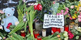 Inmitten der vielen Blumen vor dem Gebäude der Zeugen Jehovas in Hamburg-Alsterdorf liegt auch schon ein Transparent mit politischer Botschaft: „Trauer – und Wut über das fehlende Waffenverbot.“