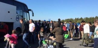 „Flüchtlinge“ besteigen im schwedischen Haparanda einen Bus, der sie in ein Aufnahmezentrum bringen soll