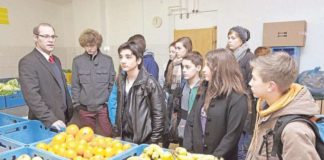 Oliver Witte (links) gibt Schülern eines Remscheider Gymnasiums einen Einblick in die Arbeit der Tafel.